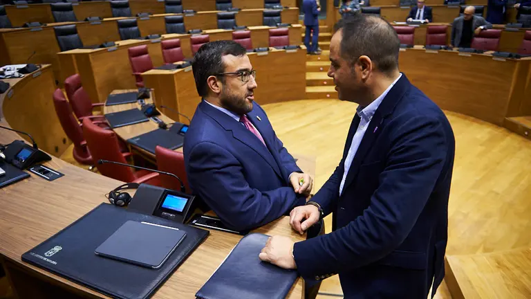 El vicepresidente del Gobierno de Navarra, Javier Remírez (i), habla con Ramón Alzórriz, portavoz de los socialistas navarros en el Parlamento. PABLO LASAOSA