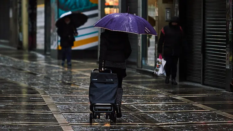 Una mujer con un carrito de la compra camina por una calle de Pamplona durante la crisis del coronavirus. PABLO LASAOSA