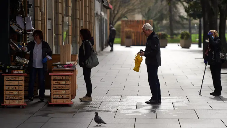 Dos personas aguardan su turno para comprar comida en una fruteria en Carlos Tercero. MIGUEL OSÉS