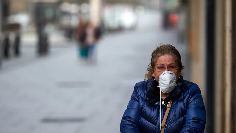 Una mujer camina por Carlos Tercero con una mascarilla durante la crisis del coronavirus. MIGUEL OSÉS