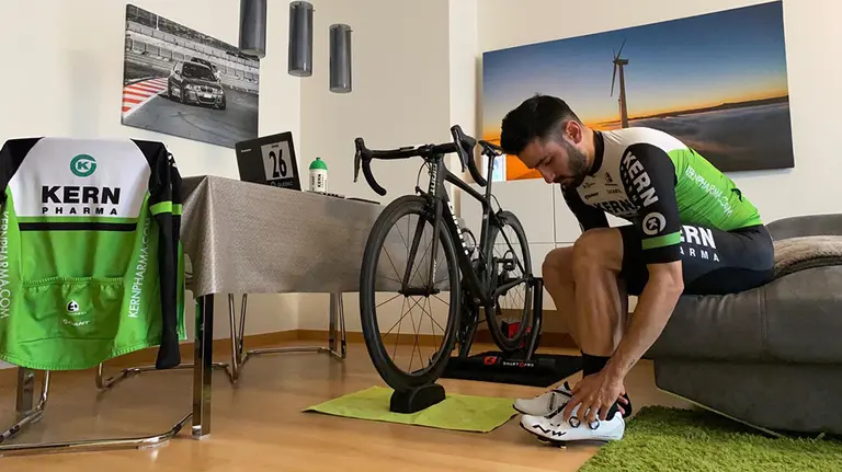 Un ciclista profesional se prepara para una ruta virtual con el rodillo y el ordenador. Cedida.