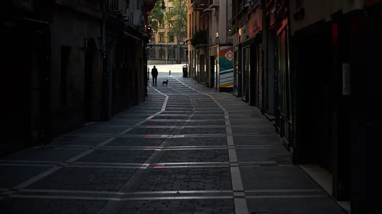 Una persona con su perro camina por las calles de Pamplona durante la crisis del coronavirus y el estado de alerta. Miguel Osés