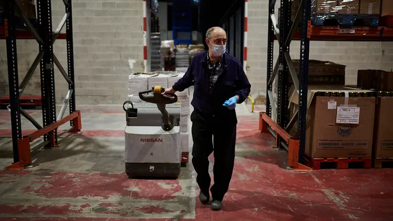Voluntarios de Banco de Alimentos de Navarra y de ASVONA empaquetan comida en cajas para llevarlas a las casas de personas con necesidad durante la crisis del coronavirus. PABLO LASAOSA