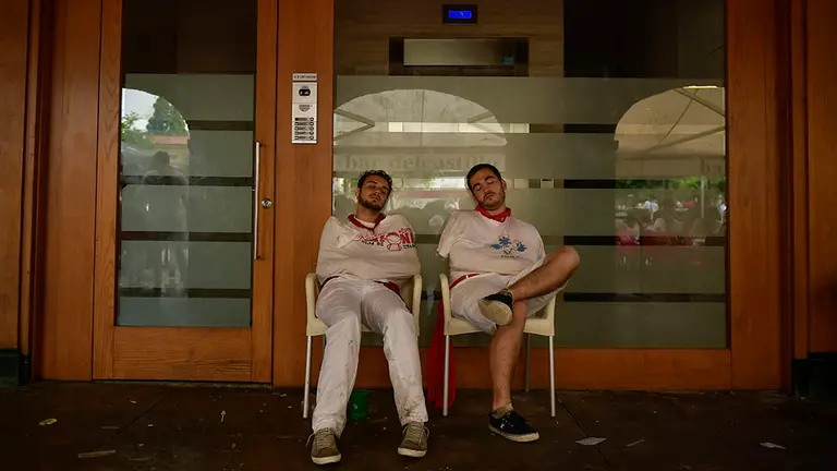 Participantes en las fiestas de San Fermín se toman un descanso durante el segundo día de fiestas de los Sanfermines de 2018 después del encierro. AP Photo/Alvaro Barrientos