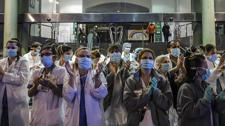 Un grupo de sanitarios aplauden a las puertas de un centro m&eacute;dico durante la crisis del coronavirus en abril de 2020.  
 (Gian Marco Benedetto)