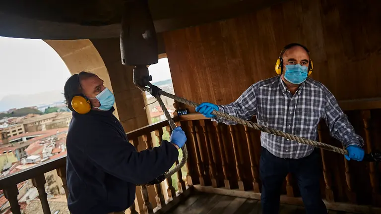 Patxi Martínez (i) es campanero desde hace 30 años y Pedro Ros desde hace 11, tocan la campana María en honor a los fallecidos por coronavirus. PABLO LASAOSA