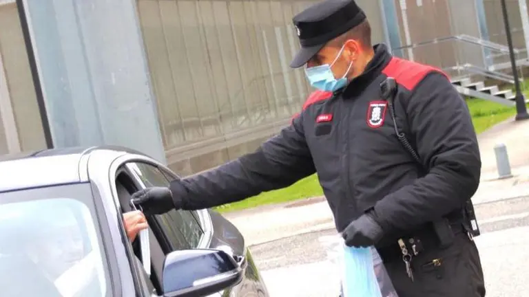 Un agente de la Policía Foral entrega una mascarilla a un conductor. POLICÍA FORAL