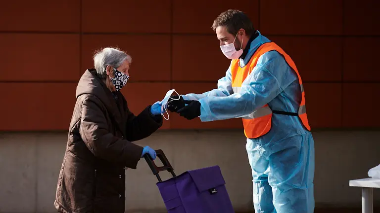 Miembros de Protección Civil reparten mascarillas en centros de salud durante la crisis del coronavirus. PABLO LASAOSA