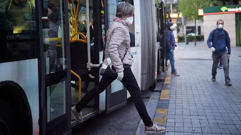 Una mujer protegida con mascarilla se baja de un autobús el día en el que se reactiva la actividad laboral no esencial en Navarra para empresas cuyos empleados no puedan teletrabajar cuando se cumple un mes desde el inicio del estado de alarma decretado a consecuencia del coronavirus, en Pamplona (Navarra, España), a 14 de abril de 2020.

14 ABRIL 2020;PAMPLONA;NAVARRA;REANUDACION;TRABAJADORES;CORONAVIRUS;VIRUS

14/4/2020
