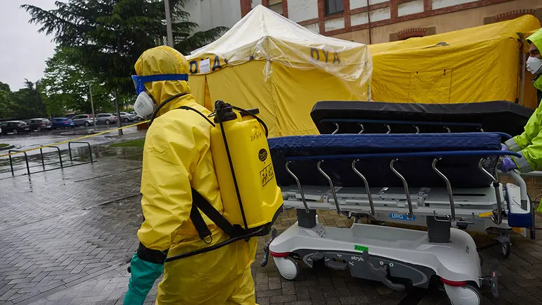 Voluntarios de la asociación sin ánimo de lucro DYA desinfectan bajo la lluvia camillas en las inmediaciones del Complejo Hospitalario de Navarra prevenir la expansión del coronavirus. En Pamplona, (Navarra), a 21 de abril de 2020.

21 ABRIL 2020;NAVARRA;PAMPLONA;EPIDEMIA;CORONAVIRUS;COVID-19;DESINFECCION;COMPLEJO HOSPITALARIO DE NAVARRA

21/4/2020