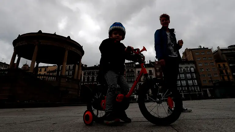 Un ni&ntilde;o juega con su madre en la Plaza del Castillo de Pamplona en una d&iacute;a donde acaba el confinamiento para los menores de 14 a&ntilde;os que pueden salir a la calle pero siempre respetando las normas que establece este nuevo decreto de estado de alarma por el coronavirus. Tendr&aacute;n que ir acompa&ntilde;ados de un adulto, podr&aacute;n salir un m&aacute;ximo de tres ni&ntilde;os por adulto, podr&aacute;n salir a la calle un tiempo m&aacute;ximo de una hora a una distancia no superior de un kil&oacute;metro de su domicilio y en un horario de 9:00 de la ma&ntilde;ana a 21:00 horas de la noche. Se les permitir&aacute; correr, saltar y hacer ejercicio, e incluso podr&aacute;n salir con juguetes, pero no podr&aacute;n usar los parques. EFE/ Jes&uacute;s Diges