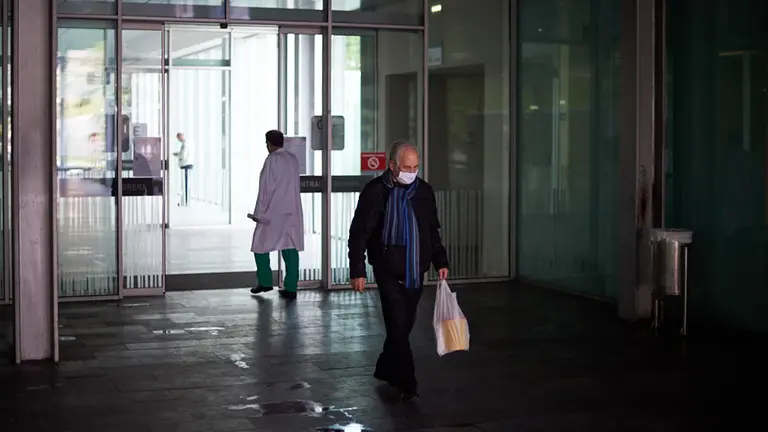 Un hombre con mascarilla sale del Complejo Hospitalario de Navarra durante la crisis por coronavirus en Pamplona. Miguel Osés