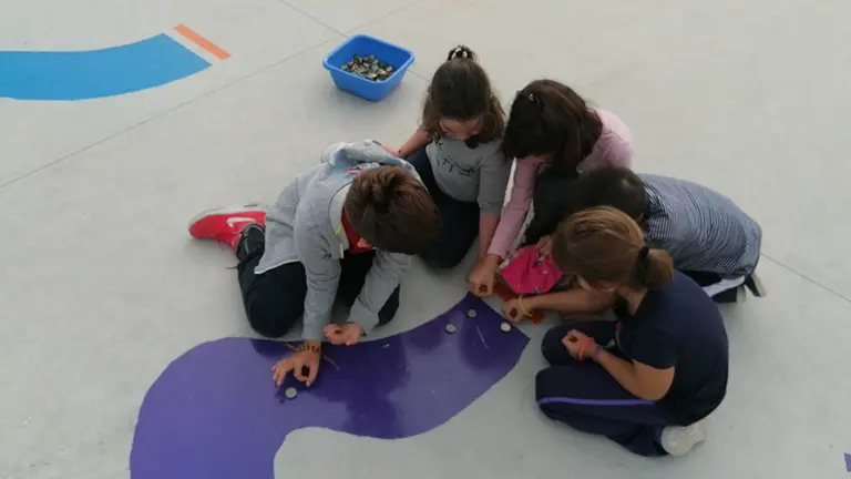 Varios niños juegan en el colegio durante el tiempo de ocio para descansar en el patio.