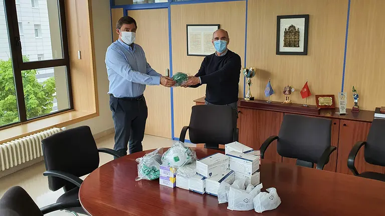 Fernando Munárriz, a la izquierda, entrega el material sanitario del Waterpolo Navarra. @PamplonaIrunaPM.