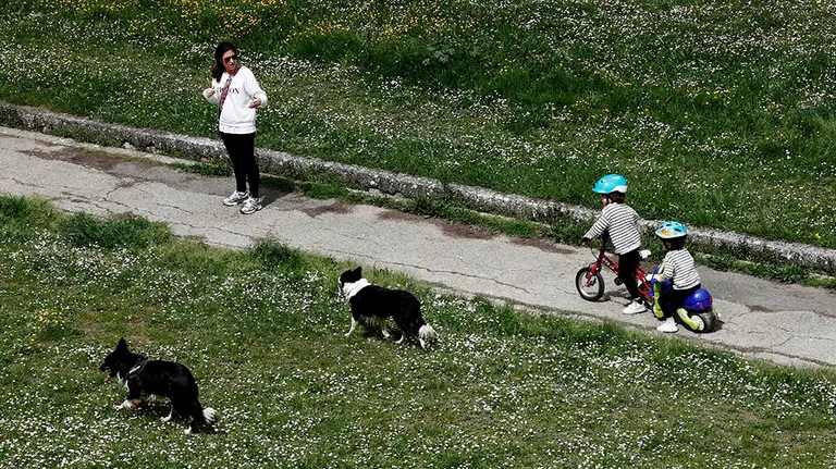 GRAFCAV5000. PAMPLONA, 29/04/2020.-  Una madre pasea con sus dos hijos y dos perros por el parque de la Ciudadela de Pamplona donde la gran cantidad de flores indican que las altas temperaturas y la primavera están ya acaparando el buen tiempo que desde el sábado sera general en toda España alcanzándose temperaturas superiores a los 30 grados. Se afronta la séptima semana de confinamiento que a partir del próximo dos de mayo contara, además de los mas pequeños, con los adultos que podrán salir a pasear y también se podrá realizar actividad física individual.  EFE/ Jesús Diges

