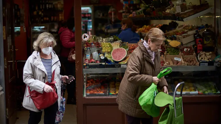 Dos mujeres, una con mascarilla, salen de la fruteria del casco viejo durante la crisis del coronavirus en Pamplona. Miguel Osés