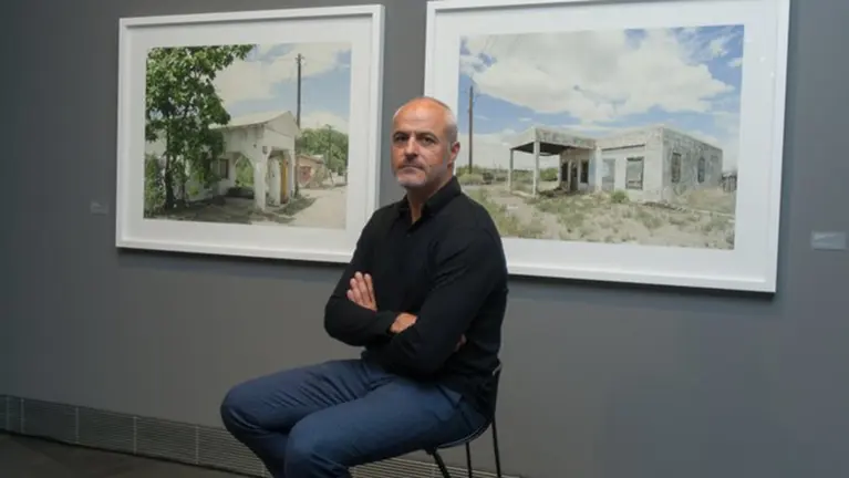 Iñaki Bergera delante de dos cuadros con antiguas gasolineras. @Museo_unav