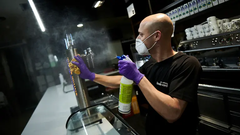 Raúl, del bar Boulevard de la Rochapea, limpia la barra en preparación para la fase 1 de la desescalada por la crisis del coronavirus. PABLO LASAOSA