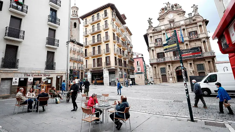 GRAFCAV5471. PAMPLONA, 11/05/2020.- La Comunidad Foral de Navarra entra hoy en la fase uno en la que comercios y terrazas de los bares, entre otros, pueden abrir sus puertas a la ciudadanía. En la imagen varios clientes toman su primer café sentados en la terraza de la Plaza del Ayuntamiento de Pamplona después de mas de 50 días de confinamiento en el que estos negocios han permanecido cerrados por el COVID-19. EFE/ Jesús Diges
