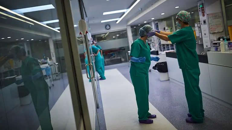 Una enfermera le ayuda a otra a quitarse las gafas de protección después de atender a un paciente covid. PABLO LASAOSA