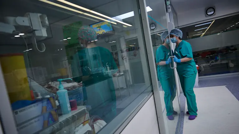 Dos enferas trabajan con una persona en la UCI. PABLO LASAOSA