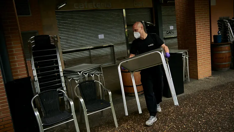 Ra&uacute;l, del bar Boulevard de la Rochapea, limpia y monta la terraza para la fase 1 de la desescalada por la crisis del coronavirus. PABLO LASAOSA