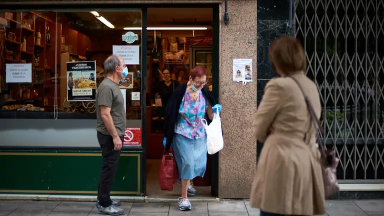Una mujer sale de la panadería durante la crisis del coronavirus en Pamplona. Miguel Osés