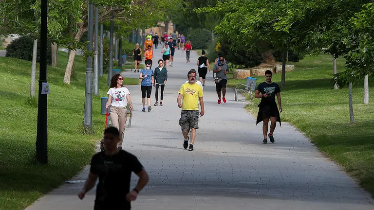 Personas caminan por el parque durante su franja horaria permitida en la desescalada ante la crisis del Covid-19 en la que mayores de 14 años y menores de 69 tienen permitidas las salidas para pasear y hacer deporte - Iván Terrón - Europa Press.