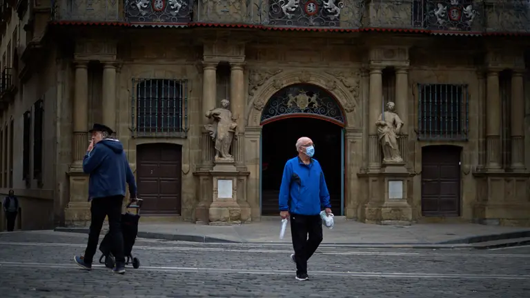 Una persona con mascarilla camina por la Plaza del Ayuntamiento durante la crisis del coronavirus en Pamplona. Miguel Osés