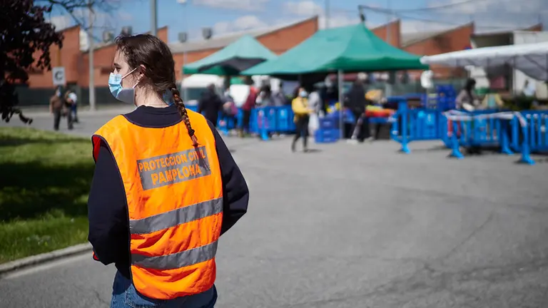 Un miembro de Protección Civil de Pamplona revisa el correcto funcionamiento del mercadillo en el primer dia de reapertura, donde también se han encargado de controlar el aforo, repartir mscarillas y ayudar a los dueños de los puestos a prepararse contra el covid19. En Pamplona, Navarra, España, a 17 de mayo de 2020. Europa Press.