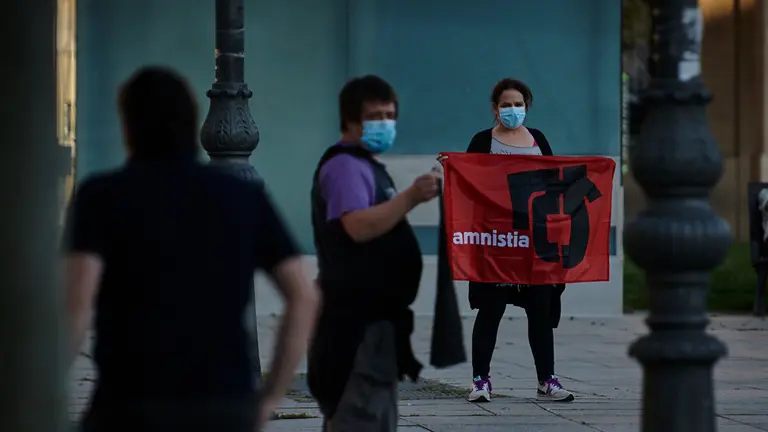 Varias personas se manifiestan en la Plaza del Castillo con el símbolo de gestoras pro amnistía. PABLO LASAOSA