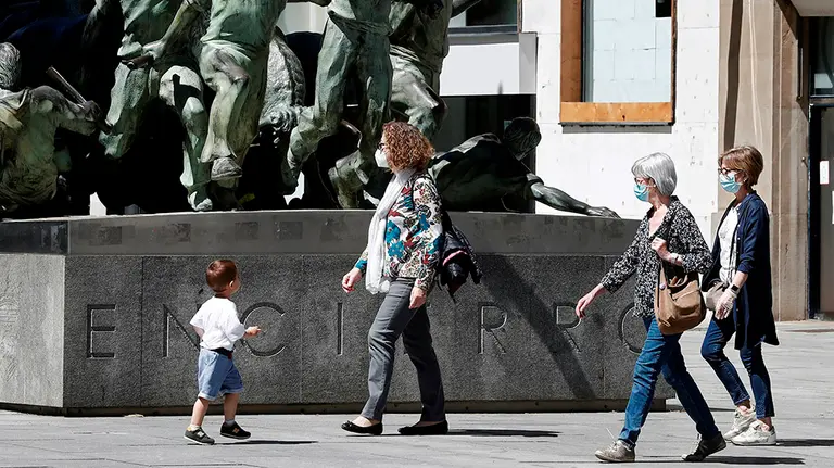 GRAFCAV5820. PAMPLONA, 20/05/2020.- Tres mujeres con mascarilla pasean por la avenida Carlos III junto al monumento al encierro donde el comercio va recuperando poco a poco la actividad trascurridos ya varios días desde que la Comunidad Foral Navarra entrara en fase uno. El uso de mascarillas será obligatorio desde este jueves en espacios cerrados y en la calle cuando no se pueda garantizar una distancia mínima de dos metros para los mayores de seis años y recomendable para los niños de entre 3 y 5 años.       EFE/ Jesús Diges
