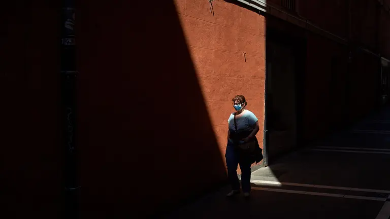 Una mujer con mascarilla pasea por las calles del casco viejo durante la crisis del coronavirus en Pamplona. MIGUEL OSÉS