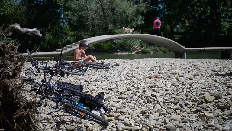 Varias personas disfrutan en las inmediaciones del río Arga durante la Fase 2 de la desescalada en Pamplona, cuando se permite el baño en ríos y riachuelos, siempre y cuando se cumplan las medidas para preservar la salud y la seguridad, donde la distancia a guardar tanto en la orilla como en el agua debe ser de dos metros. En Pamplona, Navarra (España), a 29 de mayo de 2020.

29 MAYO 2020;RIO ARGA;PAMPLONA;NAVARRA;FASE 2;DESESCALADA;COVID19

29/5/2020