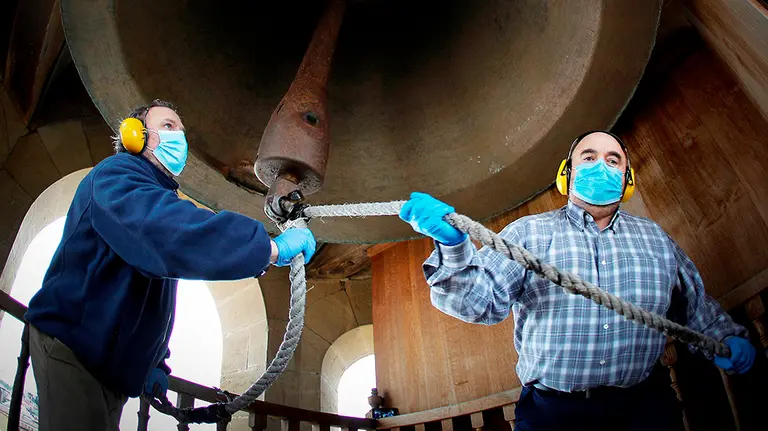 Los campaneros Pedro Ros (d) y Patxi Mart&iacute;nez (i) hacen sonar la emblem&aacute;tica campana Mar&iacute;a de la Catedral de Pamplona, la mayor en uso en Espa&ntilde;a fundida en 1584, este domingo. El lenguaje de las campanas en Navarra ha conseguido transmitirse de generaci&oacute;n en generaci&oacute;n gracias a un peque&ntilde;o grupo de campaneros que ahora esperan el retorno a una normalidad que les permita volver a poner "el alma" en su sonido. EFE/Villar L&oacute;pez