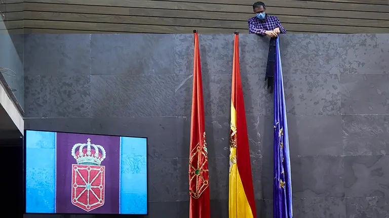 Un hombre quita los crespones negros de las banderas del Salón de Plenos del Parlamento de Navarra tras el fin del luto nacional por los fallecidos de Covid-19 y durante una sesión de la Mesa y Junta de Portavoces, en Pamplona, Navarra (España) a 4 de junio de 2020.

08 JUNIO 2020 POLÍTICA;POLÍTICA FORAL

8/6/2020