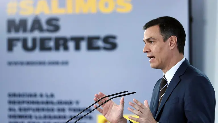 Pedro Sánchez, presidente del Gobierno, durante una de sus intervenciones junto a un cartel propagandístico de &#34;Salimos más fuertes&#34;. EFE / ARCHIVO