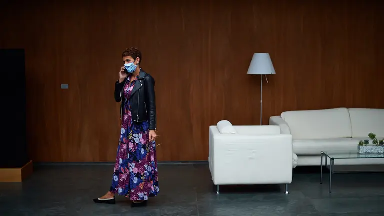 La presidenta del gobierno de Navarra habla por telefono en el atrio del parlamento momentos antes del comienzo del pleno. MIGUEL OSÉS