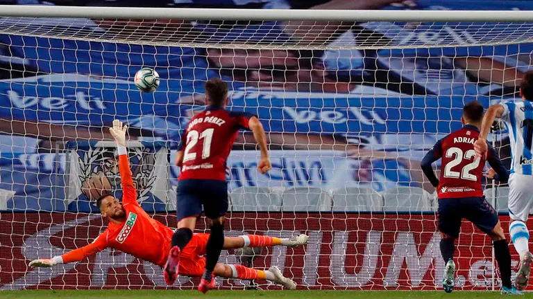 El delantero de Osasuna Adrián López (d) marca gol de penalti ante la Real Socuedad, durante el encuentro de la jornada 28 de LaLiga que se disputa este domingo en el Reale Arena de San Sebastián. EFE/ Javier Etxezarreta