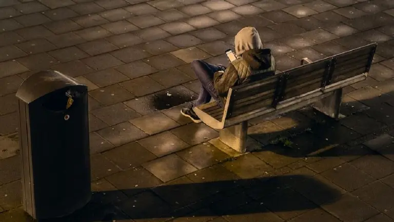 Un joven espera en un banco. ARCHIVO