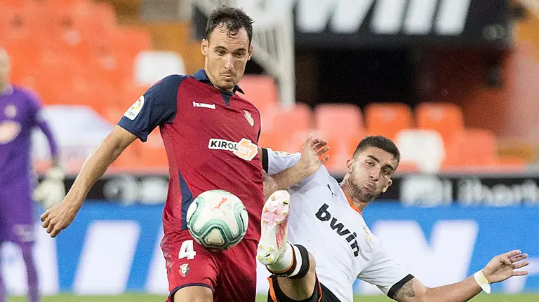 Unai García en pugna por el balón ante el Valencia en Mestalla. CA Osasuna.
