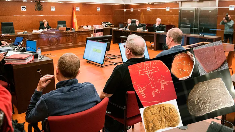 El exdirector del área arqueológica, Eliseo Gil (c), junto a los otro dos acusados, Ruben Cerdan (i) y Oscar Escribano (d), durante su declaración een el juicio. A su lado, algunas de las piezas manipuladas. EFE/ Jon Rodríguez Bilbao