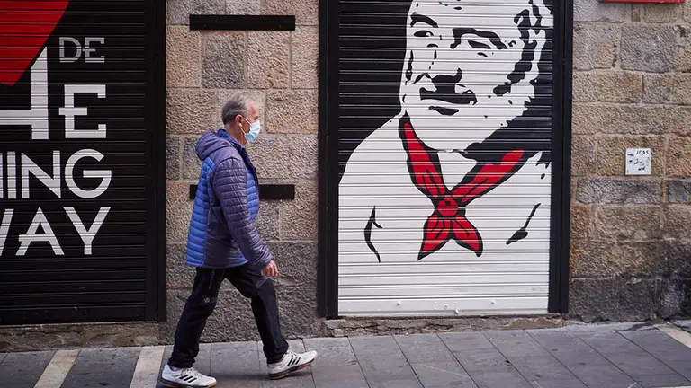 Un hombre con mascarilla pasea por el casco antiguo a primera hora de la mañana, cuando, de celebrarse, hubieran tenido lugar los encierros de los Sanfermines, en Pamplona, Navarra (España), a 5 de julio de 2020. Pamplona afronta este lunes con medidas para intentar evitar que se produzcan aglomeraciones en la ciudad en el día en el que deberían comenzar los Sanfermines de 2020, que, sin embargo, han sido suspendidos por la pandemia de Covid-19.

06 JULIO 2020;SANFERMINES;FIESTA;TRADICIÓN;TOROS;CANCELACIÓN;COVID-19;CORONAVIRUS

6/7/2020
