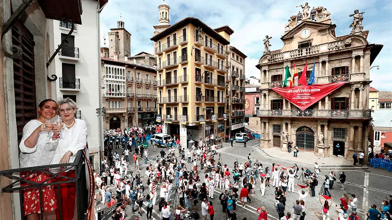 -FOTODELDIA- GRAFCAV6972. PAMPLONA, 06/07/2020.-  Paquita y Cristina, madre e hija brindan desde el balcón de su vivienda este lunes a las doce del mediodía del 6 de julio, el momento más esperado por los pamploneses, en el que debían dar inicio los Sanfermines de 2020, donde el Ayuntamiento de Pamplona ha desplegado un gran pañuelo rojo emplazando a las fiestas del próximo año con el lema "Los Viviremos". El momento esperado en la plaza Consistorial por un número controlado de personas, debido a la limitación de aforo establecida con motivo de la COVID-19, ha sido seguido con aplausos y gritos, unas muestras de alegría y tristeza, a la vez, que se han sucedido en diferentes puntos de la ciudad, donde numerosos pamploneses han quedado como es habitual en estas fechas para almorzar. EFE/ Jesús Diges
