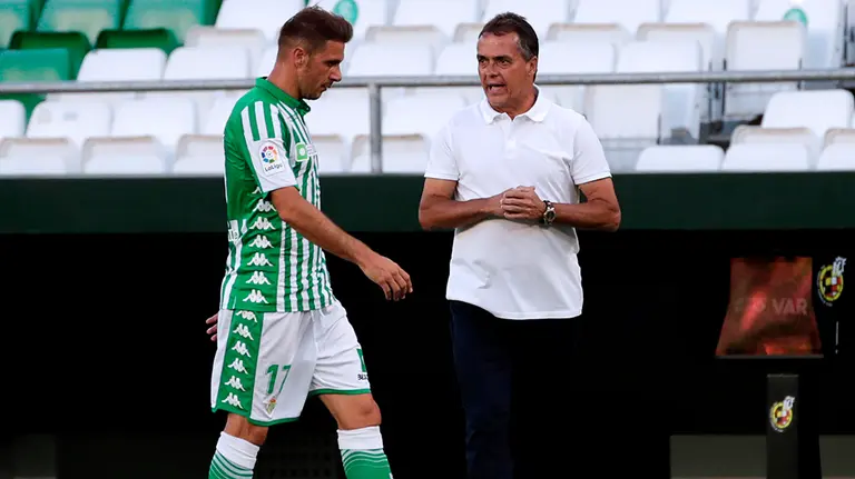 El entrenador del Betis, Alexis Trujillo, de blanco, habla con su jugador Joaquín. EFE/ Julio Munoz