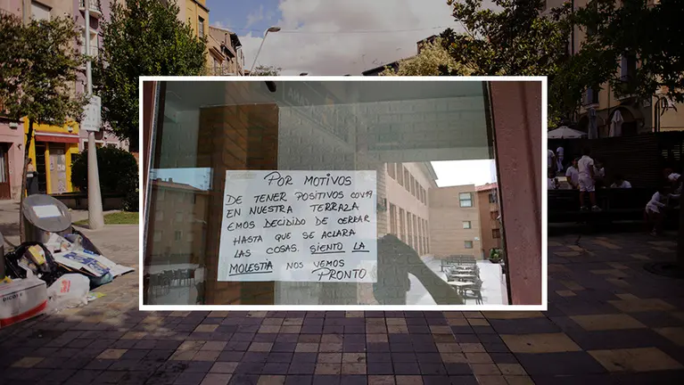 Una calle de Tudela junto al cartel colocado por un bar en la plaza de las Juderías. MIGUEL OSÉS