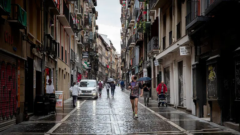 GRAF6773. PAMPLONA, 12/07/2020.- Varias personas pasean por la calle de La Estafeta de Pamplona, en una jornada en la que este domingo deberían continuar unos multitudinarios Sanfermines 2020, pero que ante la pandemia de coronavirus fueron suspendidos, la primera vez de forma completa desde 1938. EFE/ Villar López
