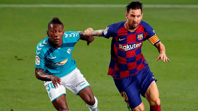 El delantero argentino del FC Barcelona Leo Messi (d), controla la pelota ante el defensa ecuatoriano del Osasuna Pervis Estupiñán (i), durante el encuentro correspondiente a la jornada 37 de primera división disputado esta noche en el estadio del Camp Nou, en Barcelona. EFE/Alberto Estévez