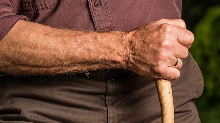 Una persona mayor camina ayudada por un bastón ARCHIVO