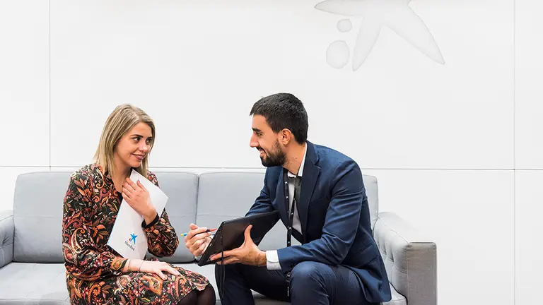 Una persona acude a una oficina para informarse de los microcrédito de CaixaBank. CEDIDA